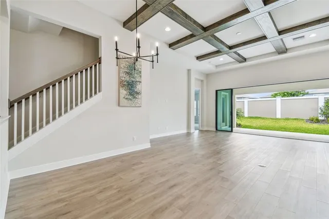 a view of a dining room with furniture a chandelier and wooden floor