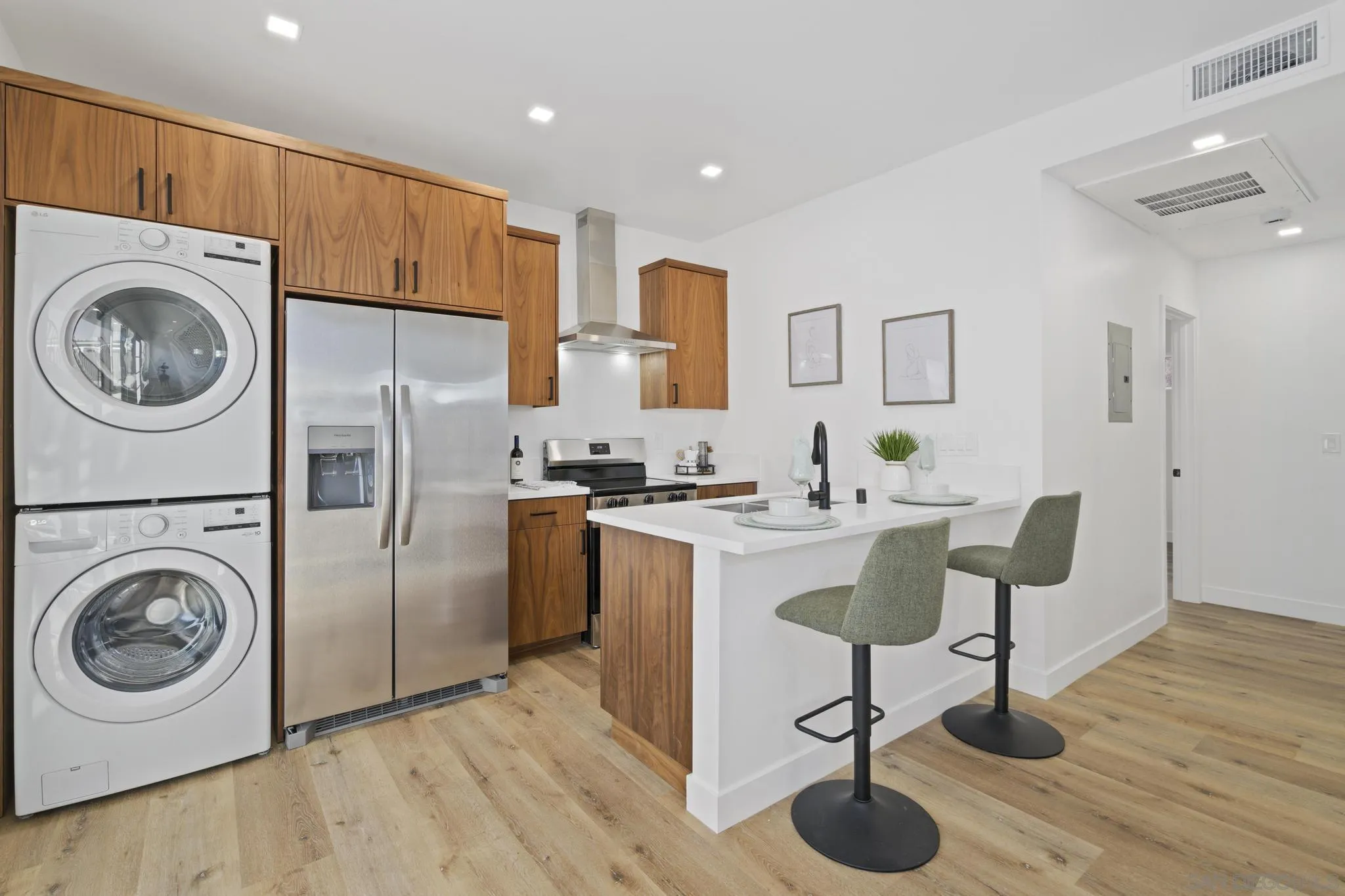 3582 Hatteras Avenue San Diego, CA 92117 - Photo 11 of 33 a kitchen with stainless steel appliances granite countertop a refrigerator a stove a sink and a dining table with wooden floor