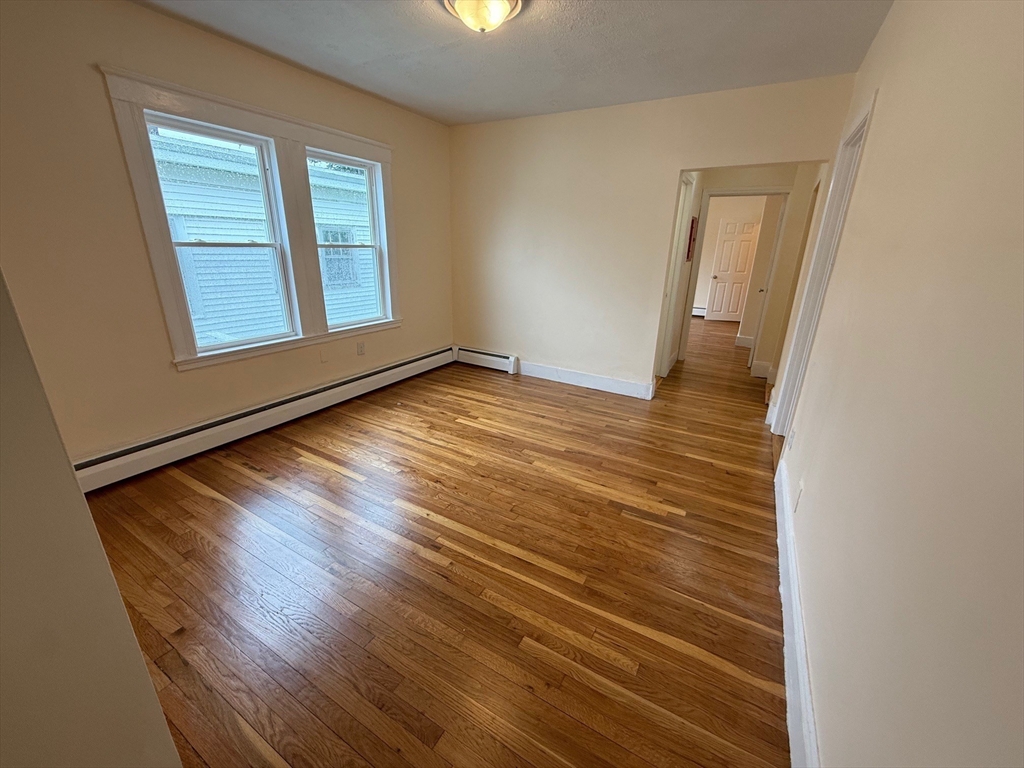 11 Dalrymple Street, Unit 3 Boston, MA 02130 - Photo 3 of 13 a view of an empty room with wooden floor and a window