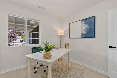 a view of a workspace with furniture and a potted plant