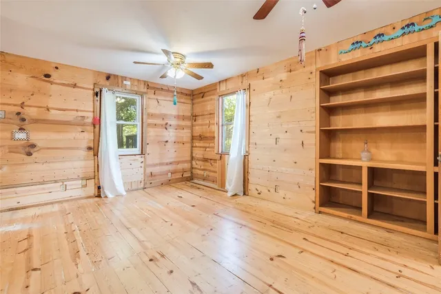 a view of empty room with wooden floor and windows