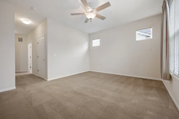 an empty room with fan and windows