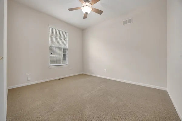 an empty room with a window and a ceiling fan