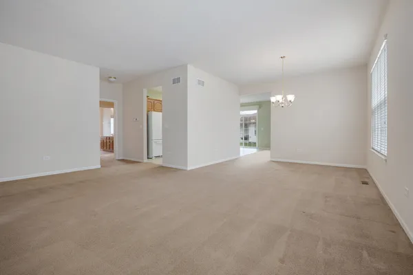 a view of a big room with windows and chandelier fan