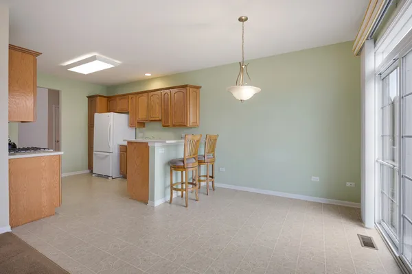 a view of kitchen with refrigerator stove and wooden floor