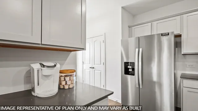 a kitchen with a refrigerator and a white cabinet