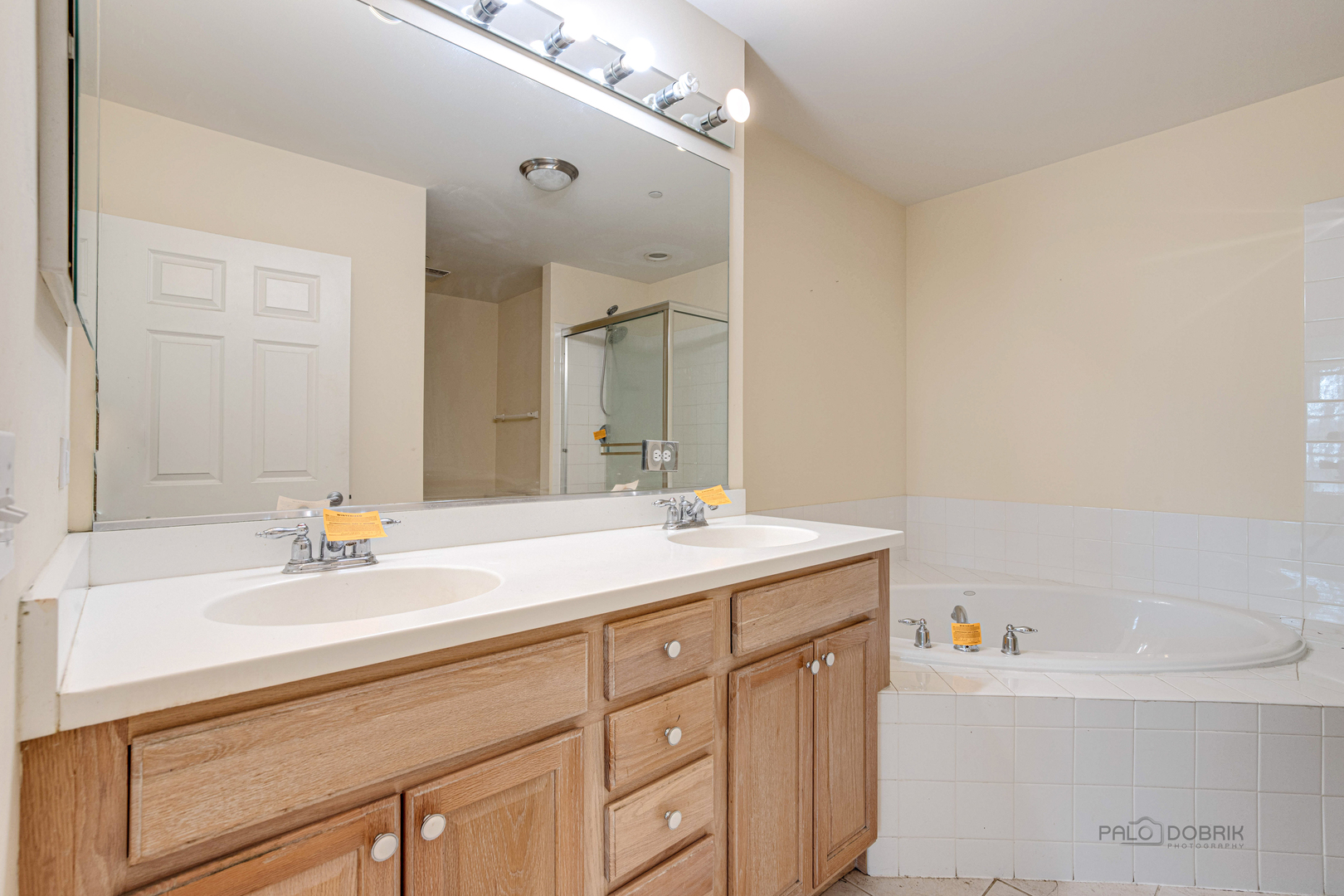 2700 Summit Drive, Unit 209 Glenview, IL 60025 - Photo 19 of 23 a bathroom with a sink double vanity granite tub and a mirror