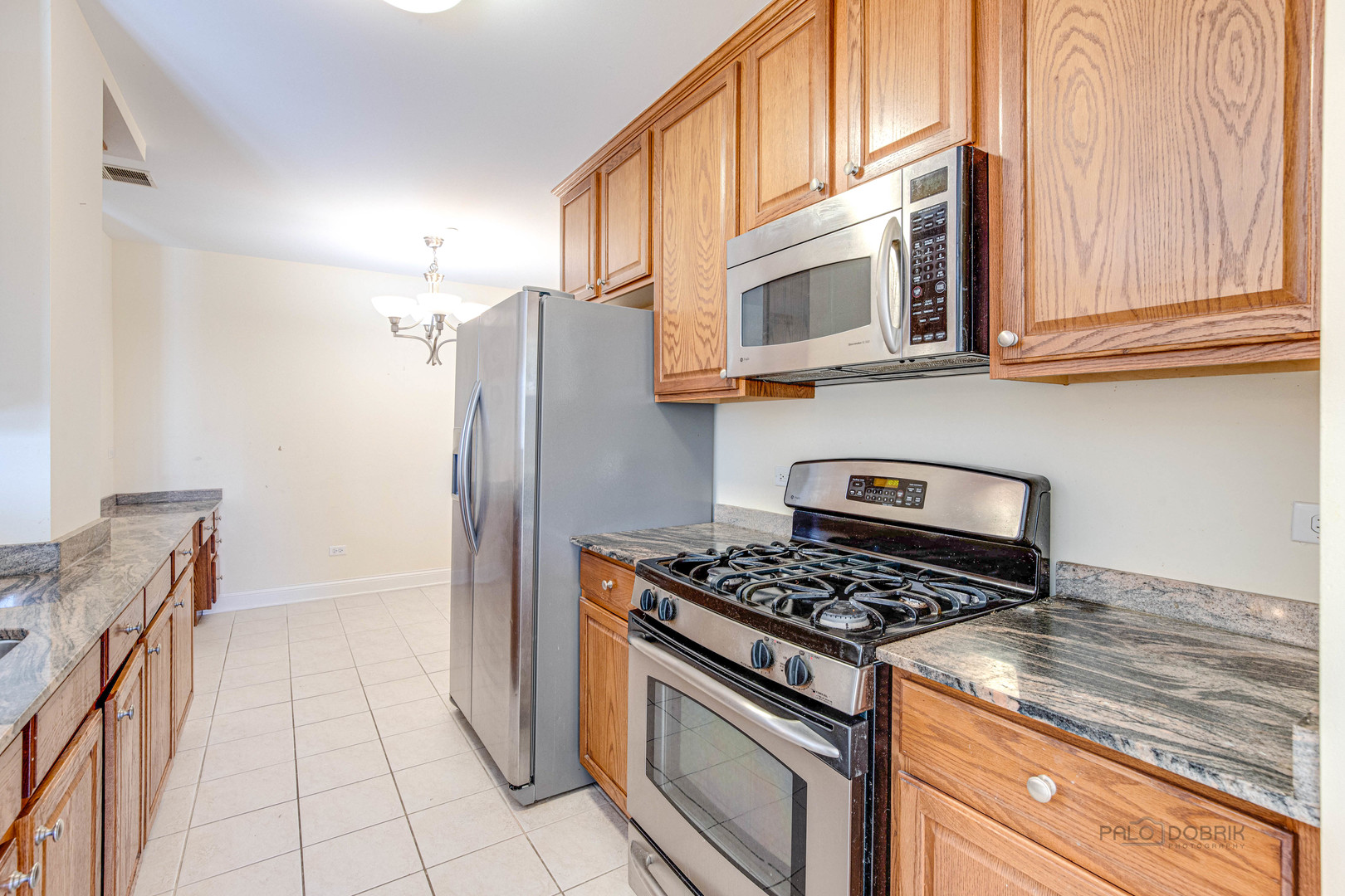 2700 Summit Drive, Unit 209 Glenview, IL 60025 - Photo 8 of 23 a kitchen with stainless steel appliances granite countertop a stove a refrigerator and a microwave