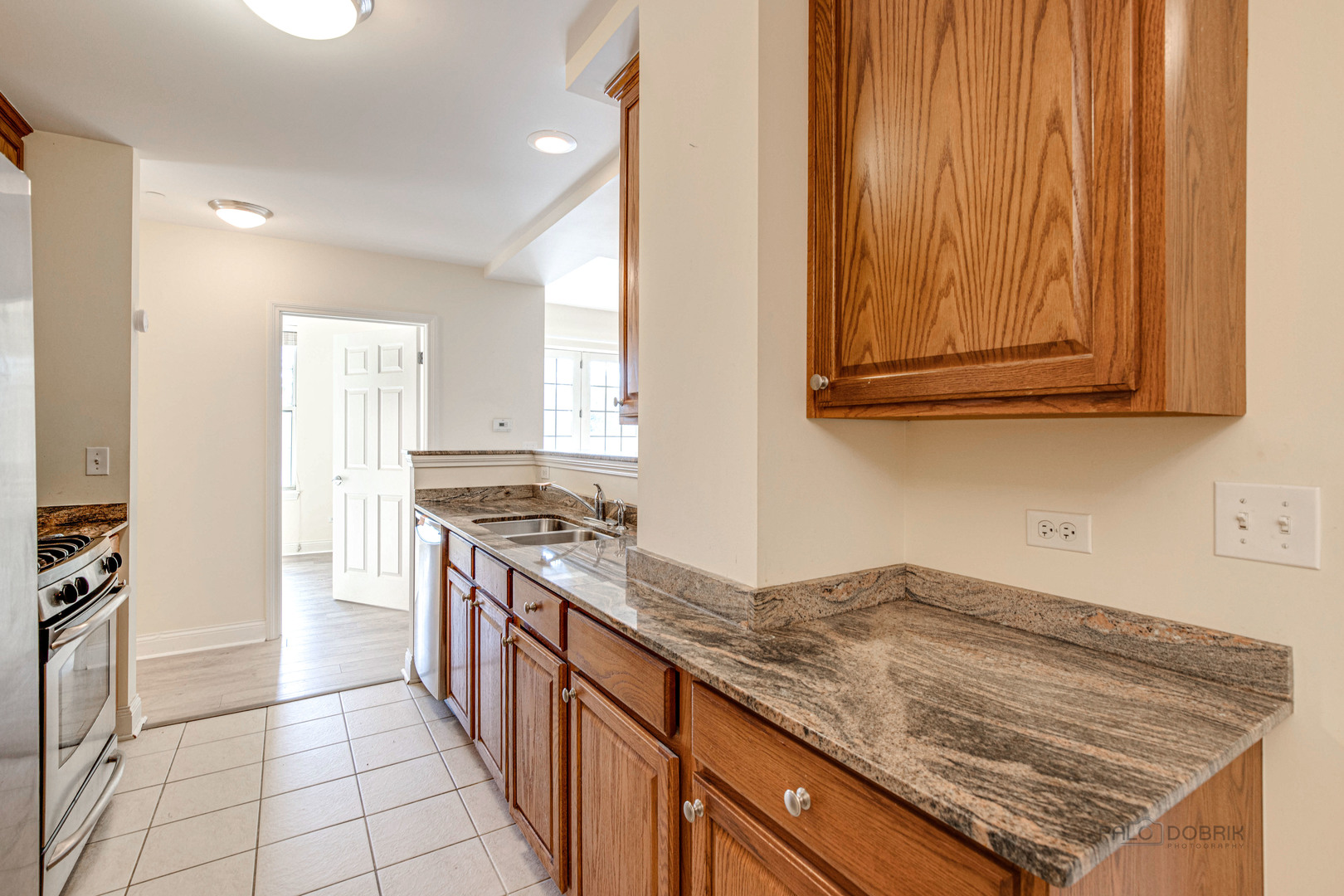 2700 Summit Drive, Unit 209 Glenview, IL 60025 - Photo 10 of 23 a kitchen with granite countertop a sink stove and cabinets