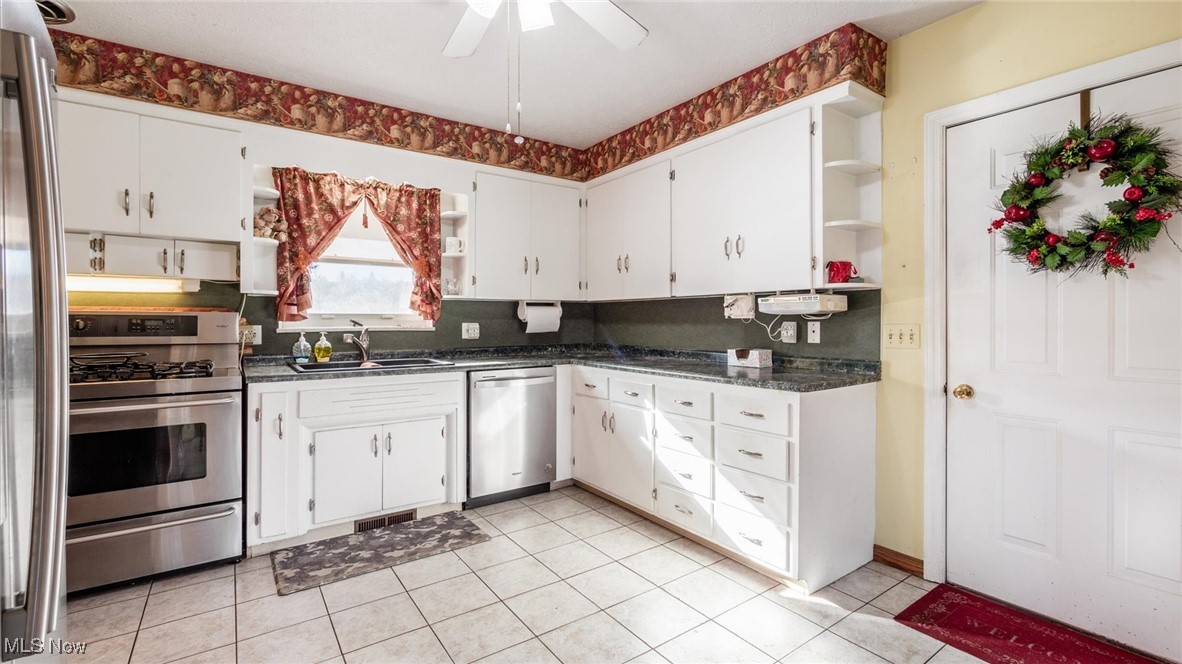 1950 Newark Road Zanesville, OH 43701 - Photo 6 of 39 Kitchen featuring sink, ceiling fan, appliances with stainless steel finishes, light tile patterned flooring, and white cabinetry