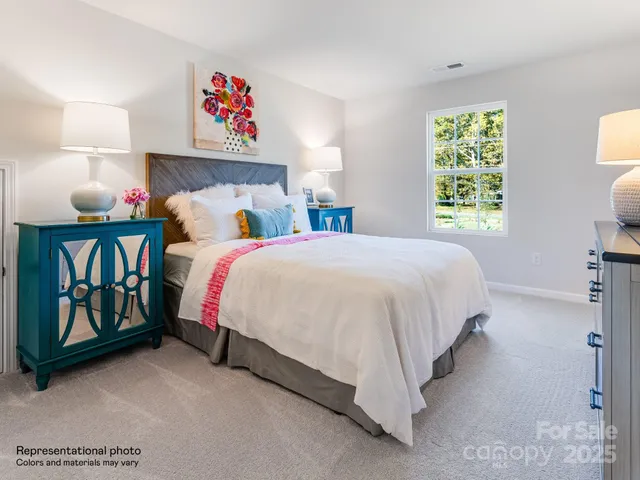 a bedroom with a bed and a lamp on dresser