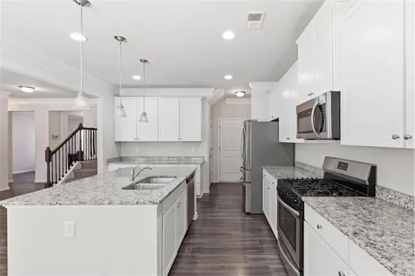 a kitchen with stainless steel appliances granite countertop a sink stove and refrigerator