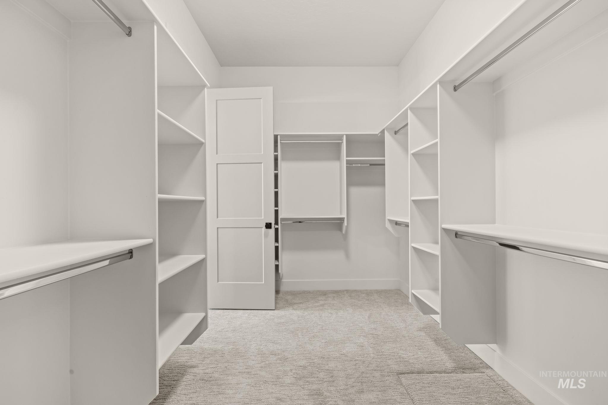 345 South Strut Way Boise, ID 83716 - Photo 33 of 50 Spacious closet with extensive built-in shelving, multiple hanging rods, and light-toned carpeting