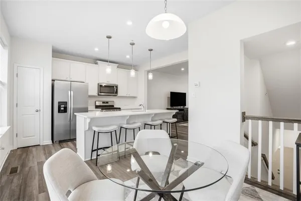 a view of kitchen with stainless steel appliances refrigerator stove dining table and chairs