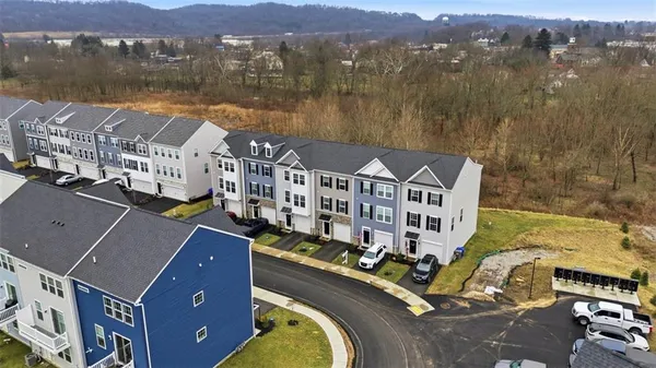 an aerial view of multiple houses with a lake