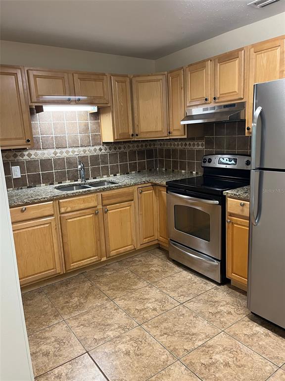 122 Northeast 37th Terrace Ocala, FL 34470 - Photo 4 of 20 a kitchen with granite countertop a sink stainless steel appliances and cabinets