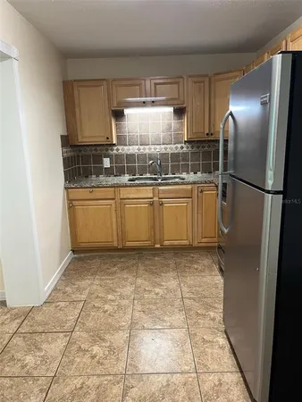 a kitchen with stainless steel appliances granite countertop a refrigerator and a stove top oven