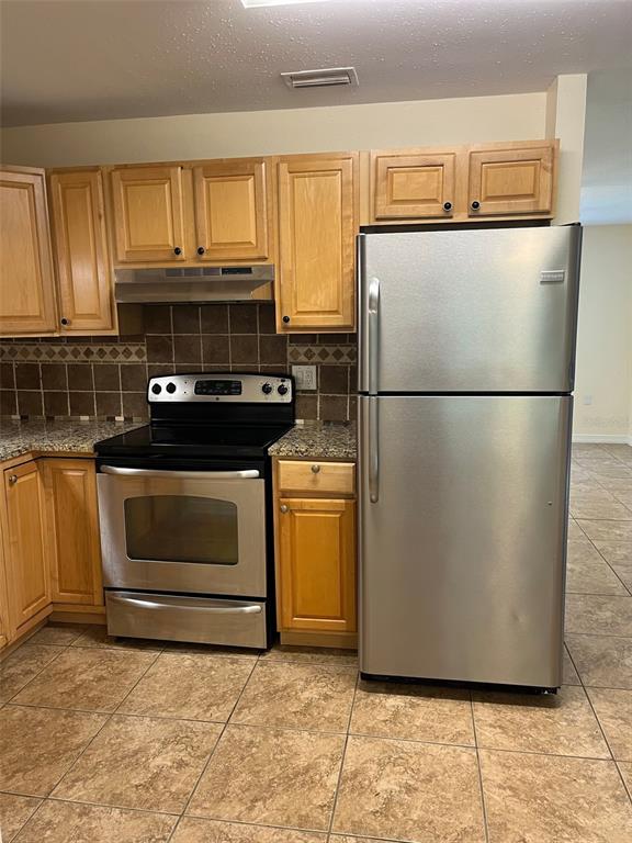 122 Northeast 37th Terrace Ocala, FL 34470 - Photo 6 of 20 a kitchen with a stove and a refrigerator