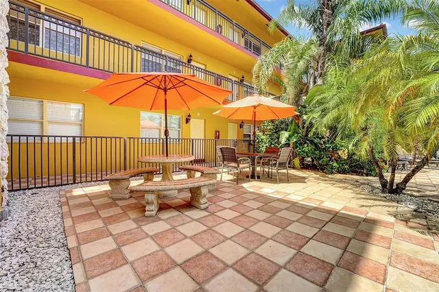 a view of a patio with a table and chairs under an umbrella
