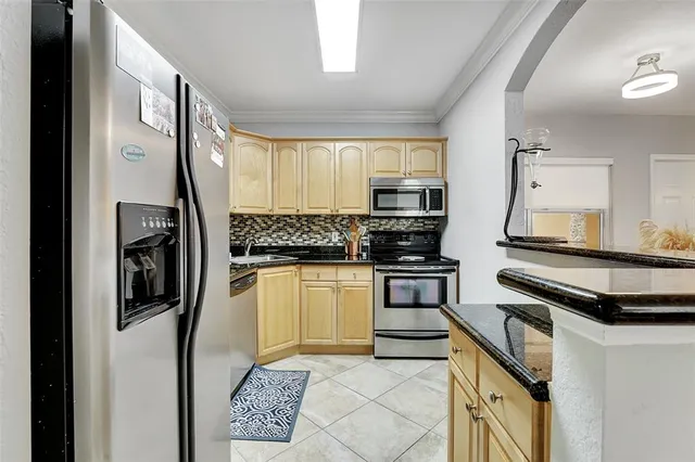 a kitchen with stainless steel appliances granite countertop a stove a sink and a refrigerator