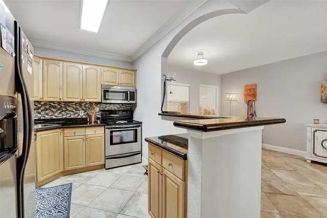 a kitchen with stainless steel appliances granite countertop a stove a microwave and a sink