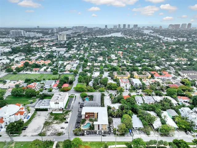 an aerial view of residential houses with outdoor space and trees