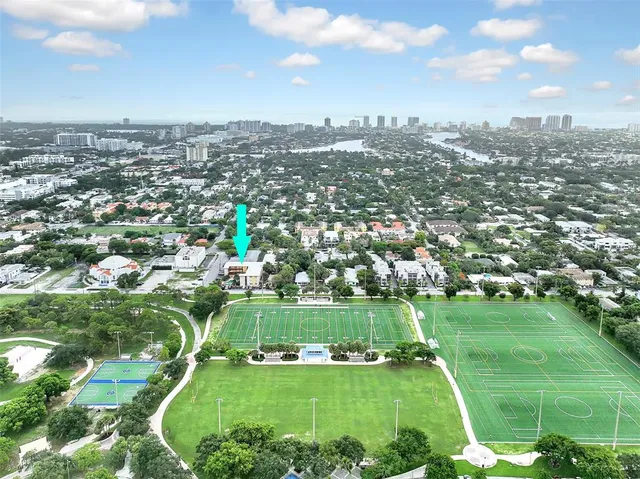 an aerial view of a houses with a yard and lake view