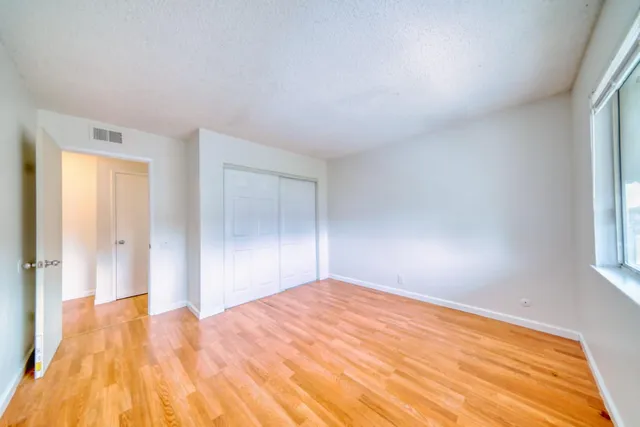 a view of empty room with wooden floor
