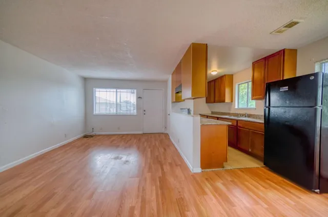 a kitchen with a refrigerator and wooden floor