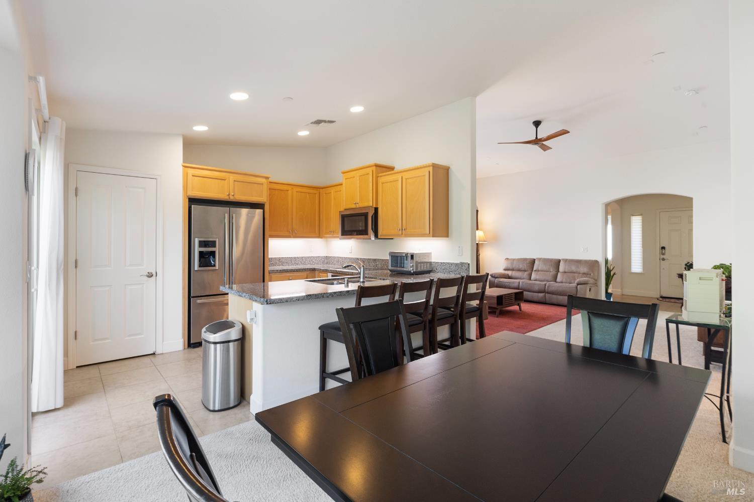 319 Birch Ridge Drive Rio Vista, CA 94571 - Photo 9 of 28 a kitchen with stainless steel appliances granite countertop a stove top oven a sink a dining table and chairs with wooden floor