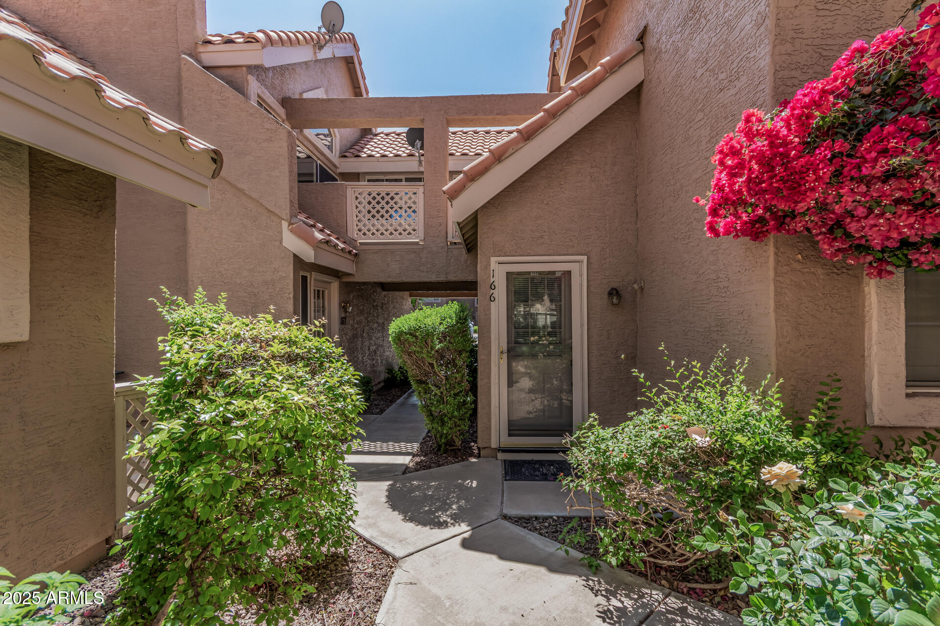1633 East Lakeside Drive, Unit 166 Gilbert, AZ 85234 - Photo 4 of 43 a front view of a house with lots of flower plants