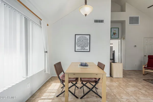 a dining room with stainless steel appliances granite countertop a stove top oven a sink dishwasher a dining table and chairs with wooden floor