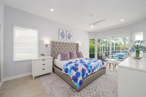 a bedroom with a large bed and a potted plant