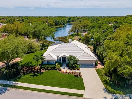 an aerial view of a house with a yard and lake view