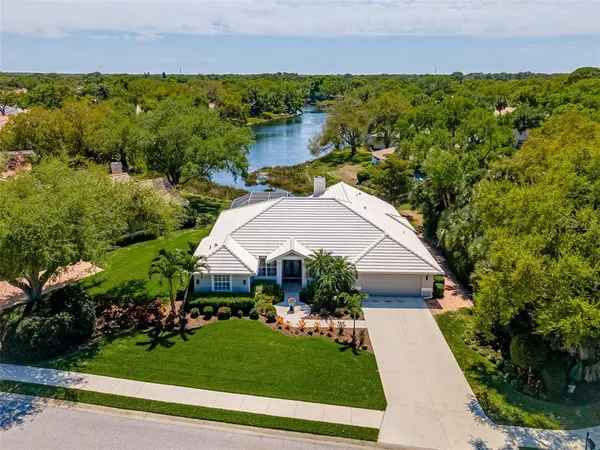 an aerial view of a house with a yard and lake view
