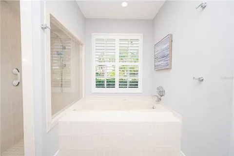a spacious bathroom with a granite countertop sink a mirror a vanity and a shower