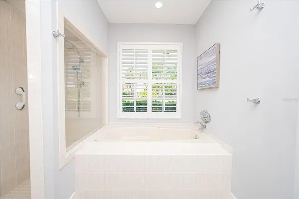a spacious bathroom with a granite countertop sink a mirror a vanity and a shower