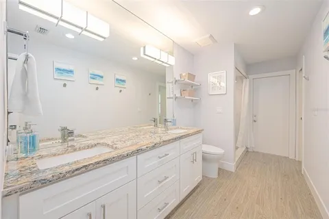 a kitchen with stainless steel appliances kitchen island granite countertop a stove a refrigerator a sink a dining table and chairs