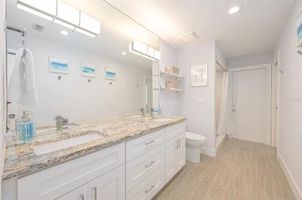 a kitchen with stainless steel appliances kitchen island granite countertop a stove a refrigerator a sink a dining table and chairs