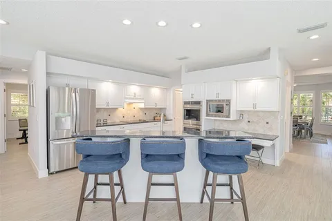 a kitchen with counter top space sink and wooden floor