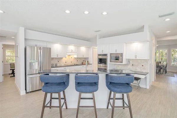 a kitchen with counter top space sink and wooden floor