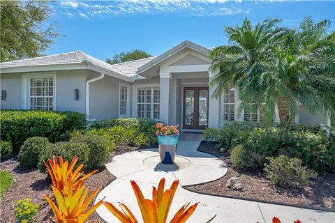 a front view of a house with a yard and potted plants