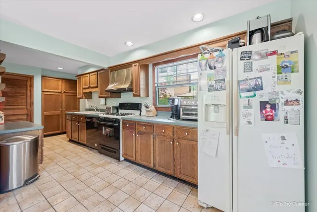 a kitchen with granite countertop a refrigerator and a sink