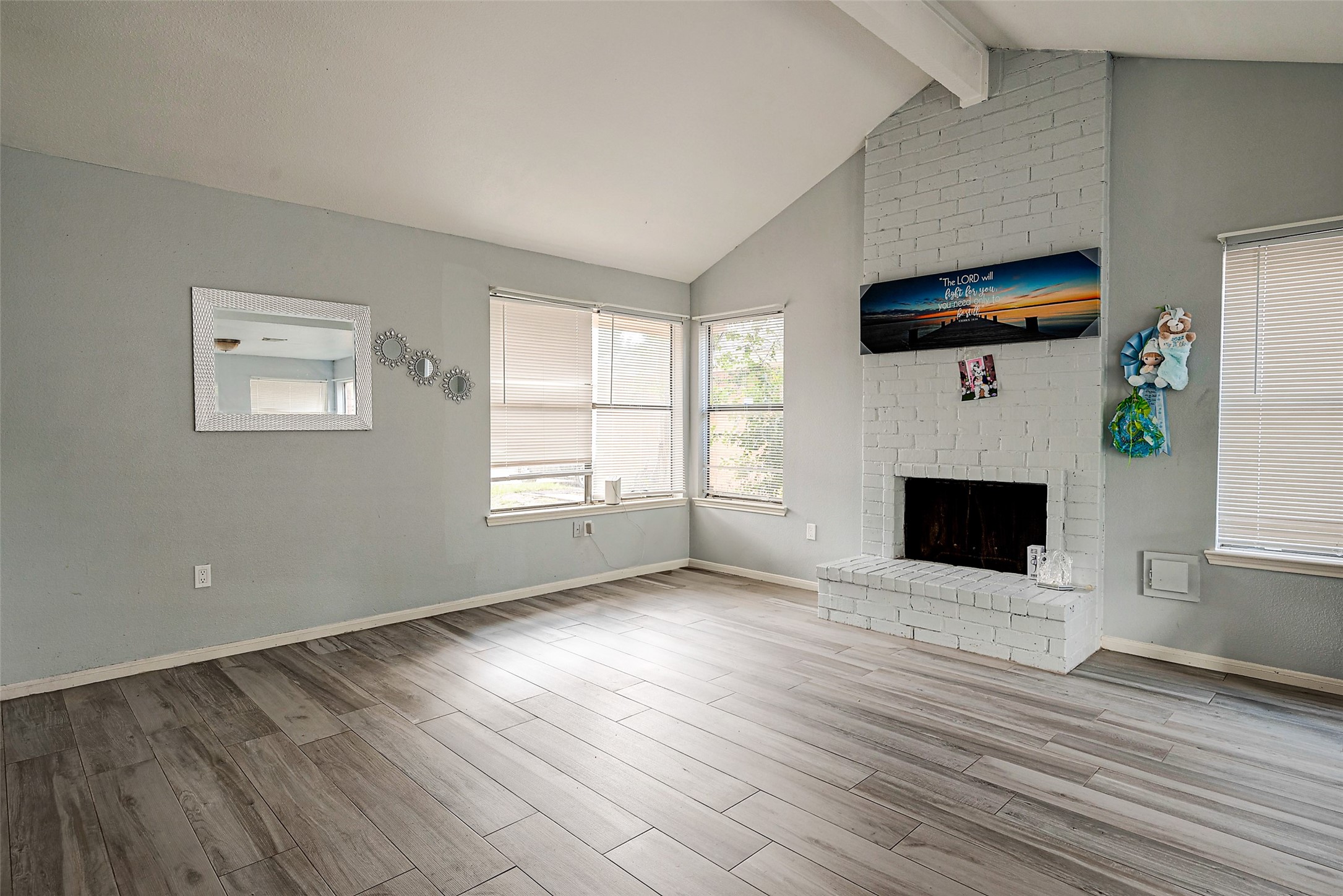 2226 Gray Hawk Lane Katy, TX 77449 - Photo 10 of 16 an empty room with windows fireplace and wooden floor