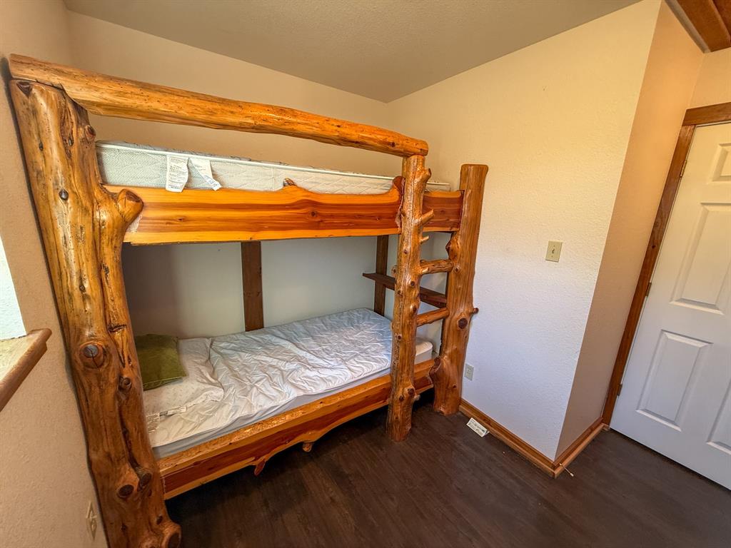 4909 Barton Chapel Road Jacksboro, TX 76458 - Photo 15 of 37 a bedroom with a bed and wooden floor