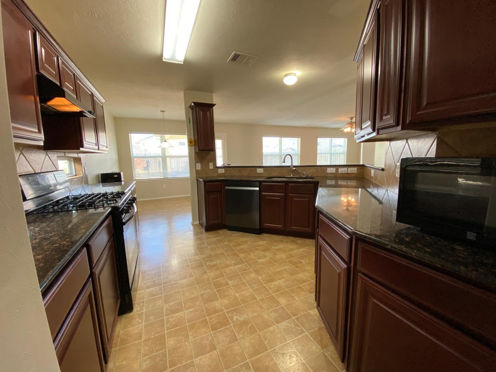 1515 Daffodil Road Missouri City, TX 77489 - Photo 4 of 20 a kitchen with stainless steel appliances granite countertop a stove top oven a sink and a granite counter tops