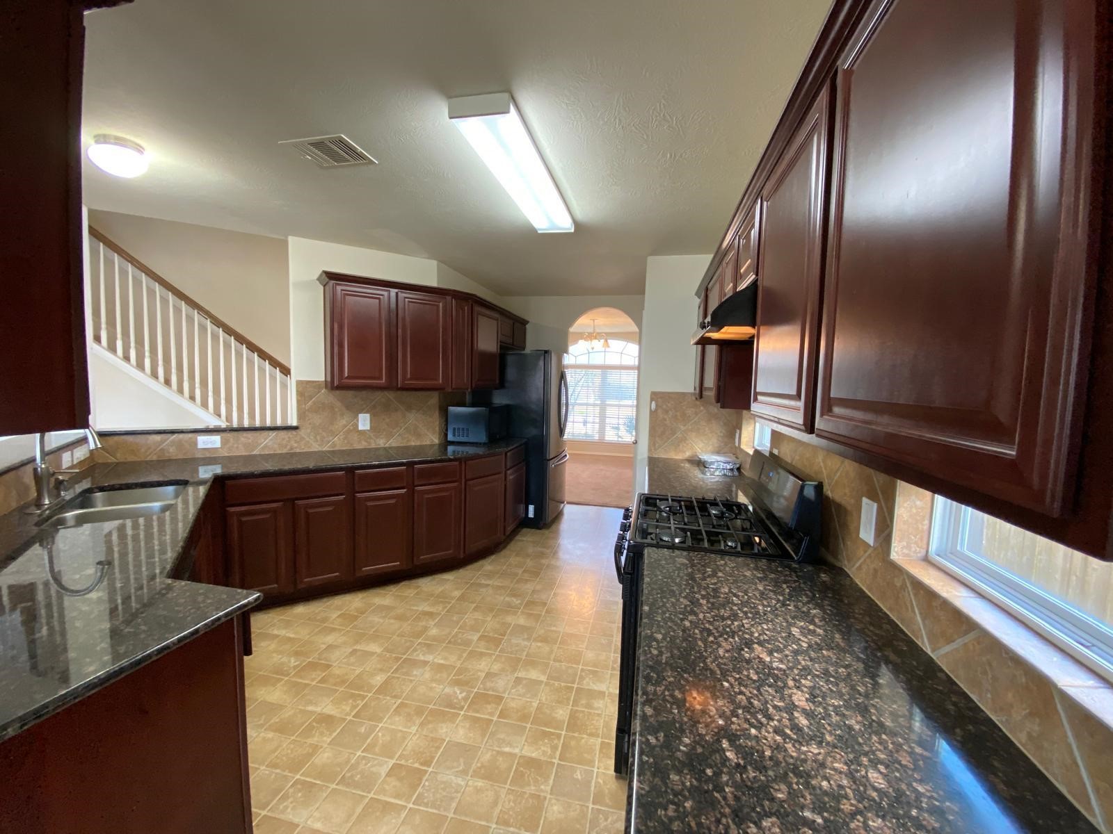 1515 Daffodil Road Missouri City, TX 77489 - Photo 5 of 20 a kitchen with stainless steel appliances granite countertop a stove a sink and a microwave