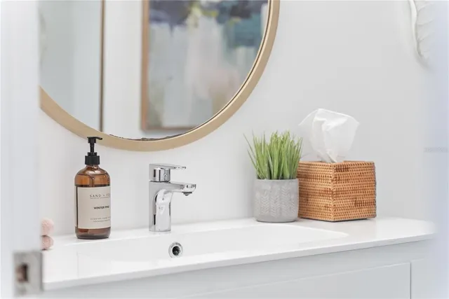 a bathroom with a sink a potted plant and a mirror