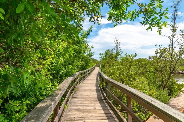 a sign board with a house in the background