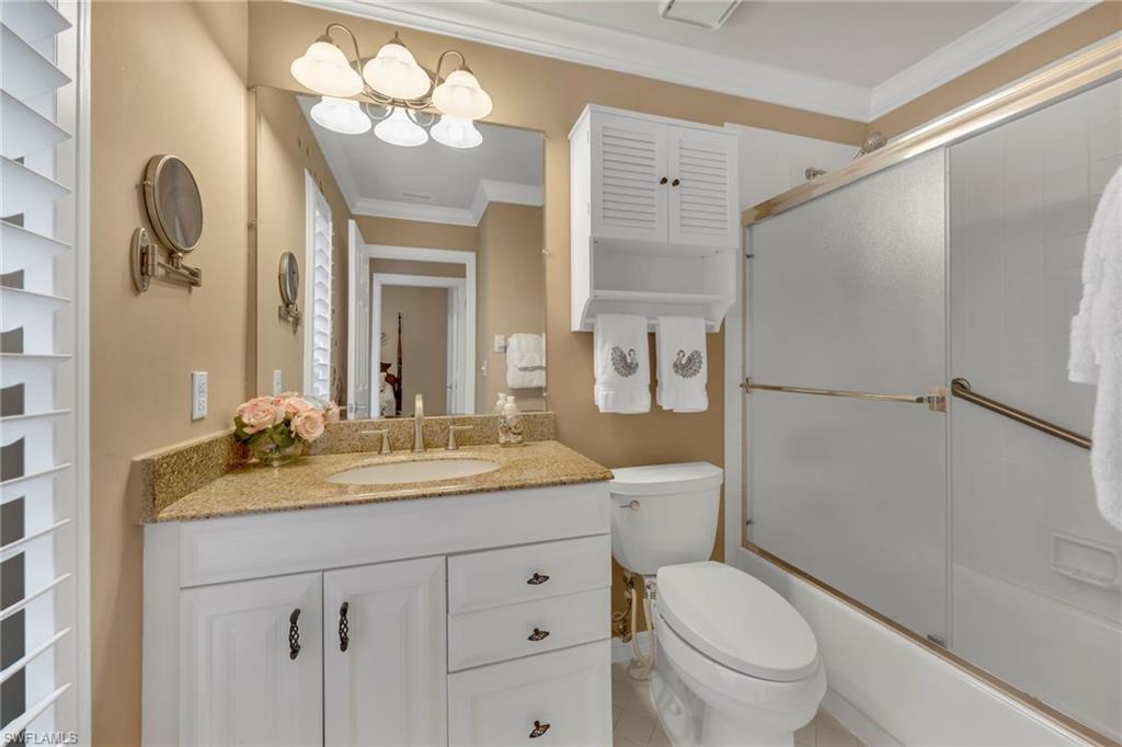 5101 Mabry Drive Naples, FL 34112 - Photo 13 of 18 a bathroom with a granite countertop sink toilet a mirror a vanity and shower